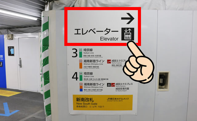 「エレベーター →」の案内板